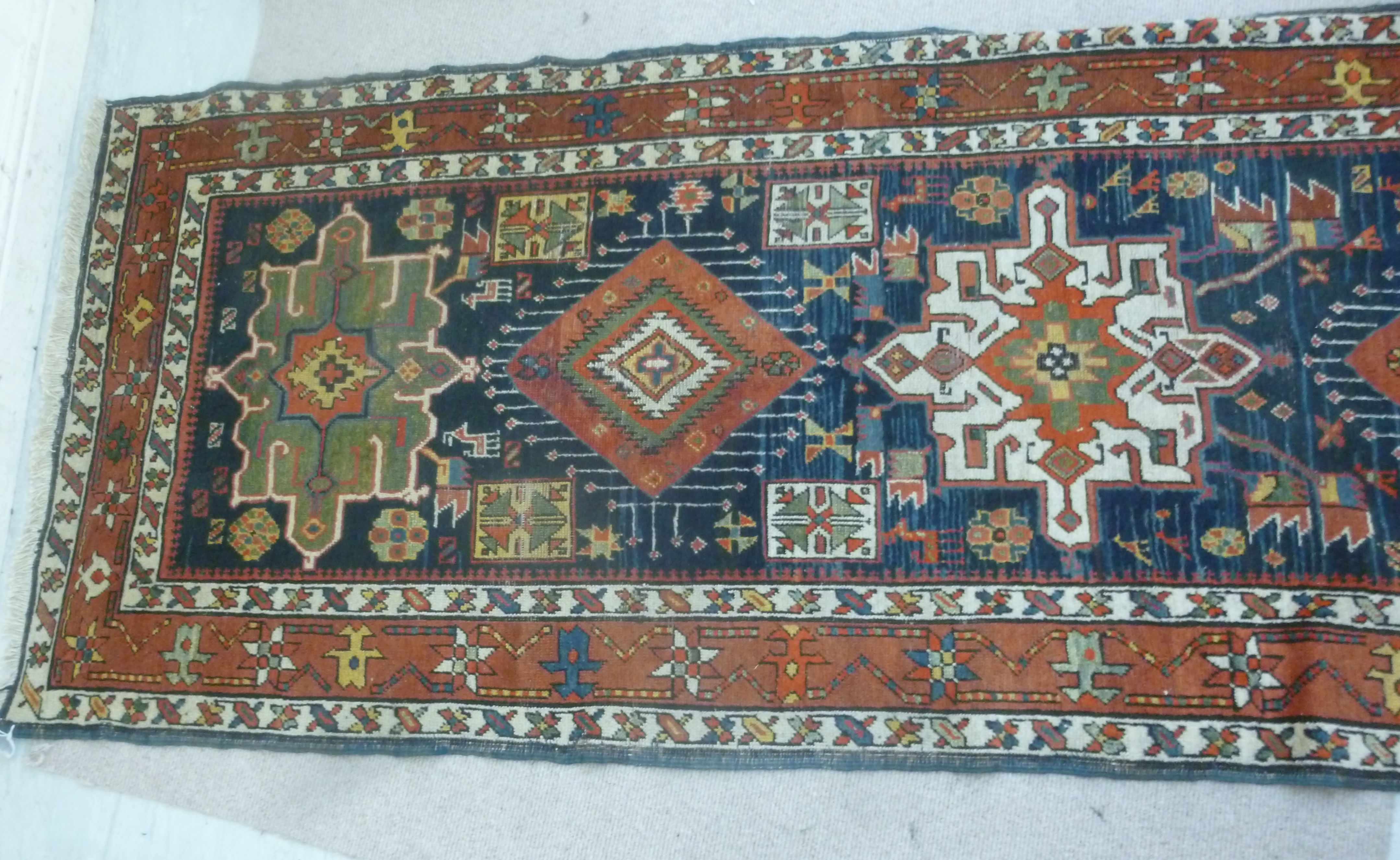 A Caucasian runner with repeated stylised diamond motifs on a blue and red ground 154'' x 39'' - Image 4 of 5