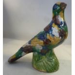 A late 18th/early 19thC Chinese 'egg and spinach' glazed pottery model bird, perched on a stone 6.