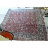 A Persian carpet with stylised designs bordered by foliage 333'' x 296''