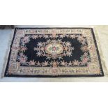 A Chinese washed rug with a central floral medallion,