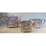 A Chinese three piece silver tea set comprising a teapot of rectangular box design with canted