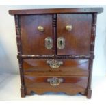 An early 20thC mahogany desktop collector's cabinet in the form of a miniature compactum,