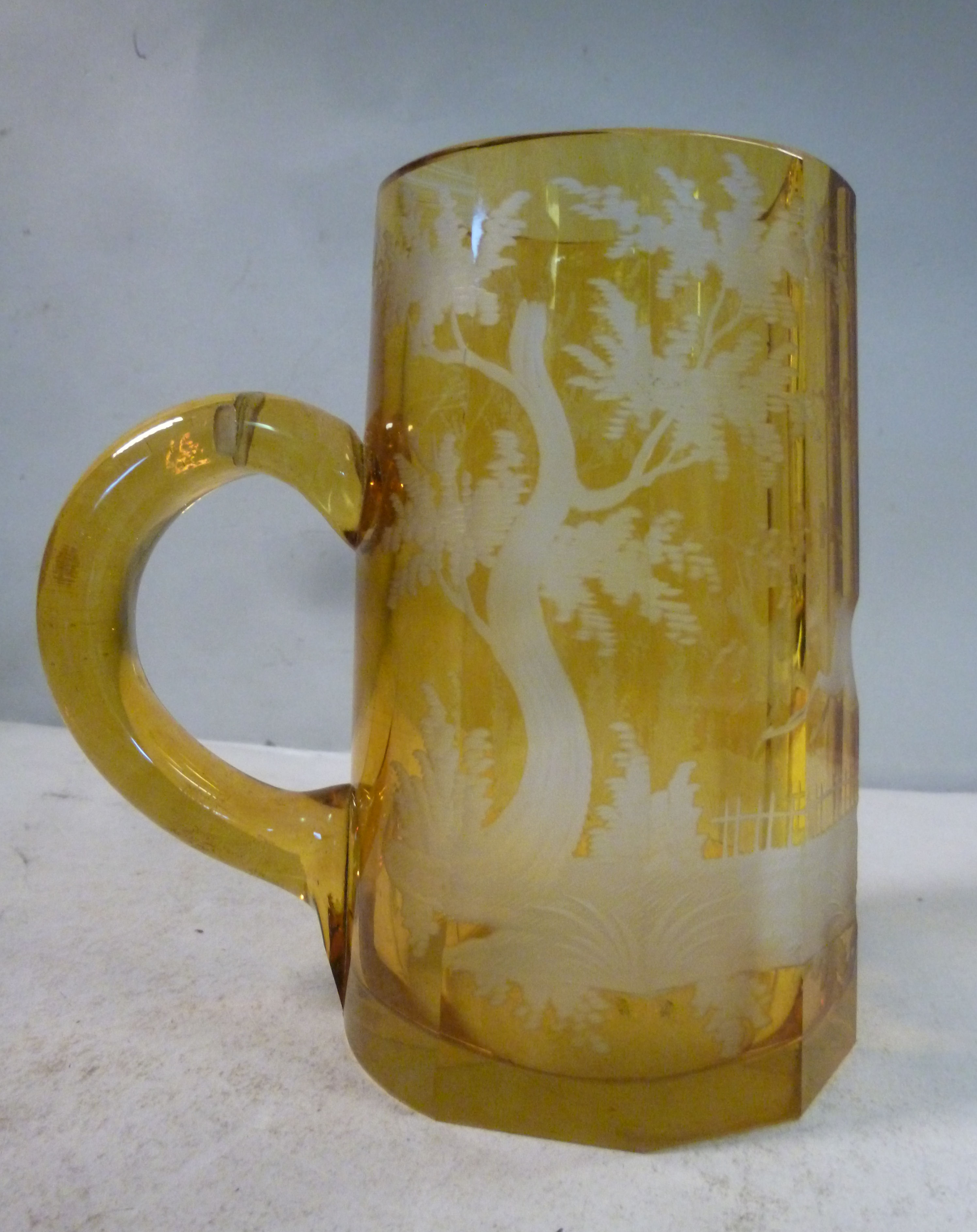 An early 20thC Bohemian amber coloured glass tankard of tapered, multi-panelled, facet cut form, - Image 2 of 3