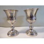 A pair of silver coloured metal Kiddush cups with foliate ornament and gilded interiors