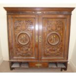 A late Victorian coloured oak, satinwood and ivory marquetry hanging cupboard with a level,