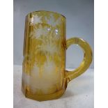 An early 20thC Bohemian amber coloured glass tankard of tapered, multi-panelled, facet cut form,