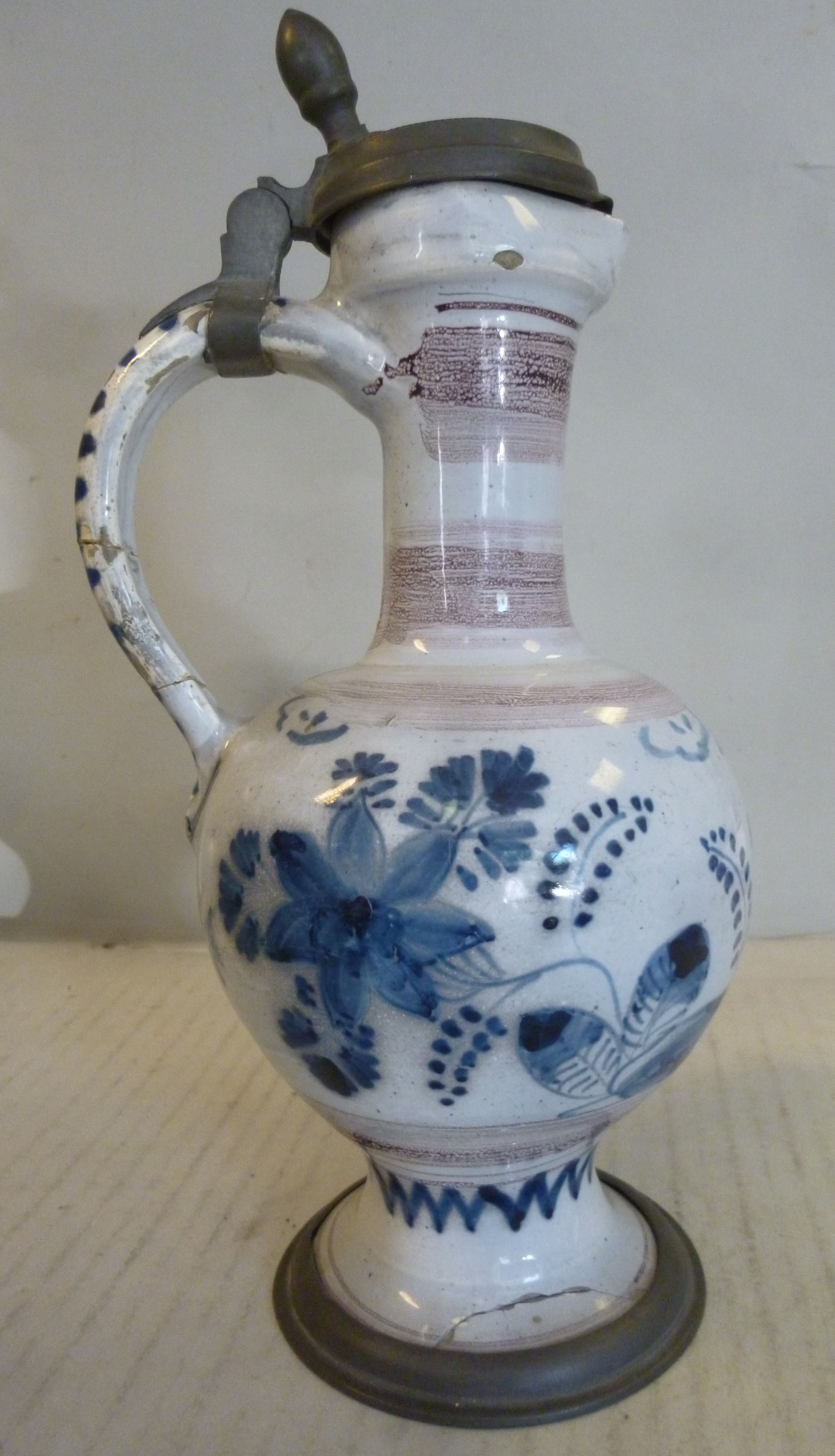 An 18thC German/North European Delftware ewer of bulbous form with a long narrow neck, loop handle,