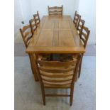 A Frank Hudson dowelled, honey coloured oak refectory table with a panelled top, raised on square,