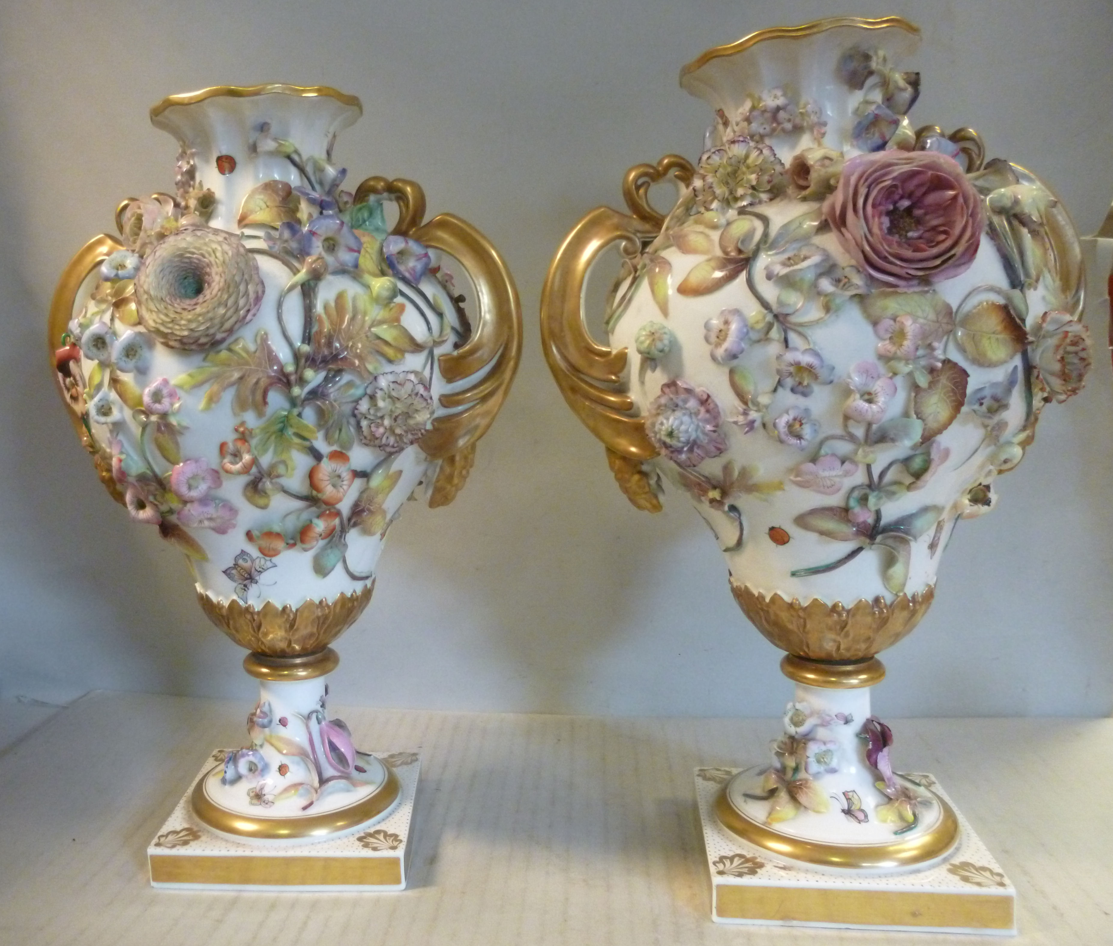 A pair of Chamberlains Worcester ivory glazed and floral encrusted gilded and painted pear shaped,