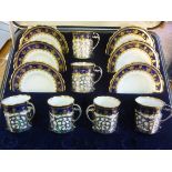 A set of six Aynsley china coffee cans and saucers with six pierced and scrolled silver cup frames