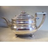 A George III silver teapot of oval ogee form with a gadrooned rim, a swept spout,