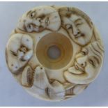 A late 19th/early 20thC carved ivory doughnut shaped netsuke,