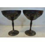 A pair of silver cups, each wide, shallow, foliate scroll engraved bowl,