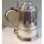 A George II silver tankard of tapered cylindrical form with applied wire bands, a domed,