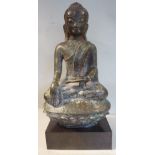 An Asian 'antique' cast bronze figure, a young God, seated crosslegged on a lotus flower pillow 8.