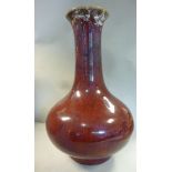 A late 19thC Chinese sang de boeuf porcelain bottle vase with a long tapered neck and flared rim