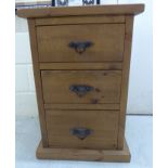 A modern CPW rough sawn planked pine, three drawer bedside chest with wrought iron fittings,