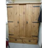 A modern CPW rough sawn planked pine wardrobe with wrought iron fittings,