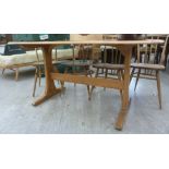 An Ercol pale coloured elm dining table, the top with round corners,