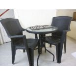 A modern black painted metal terrace table,