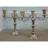 A pair of silver plated bead bordered candelabra,