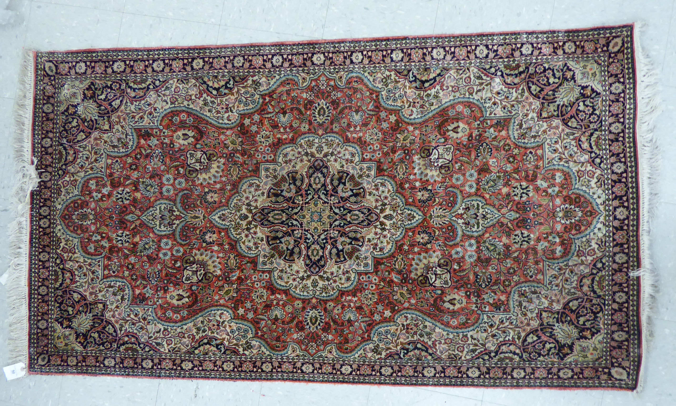 A modern silk rug with a central serpentine outlined medallion, bordered by flora and foliage,