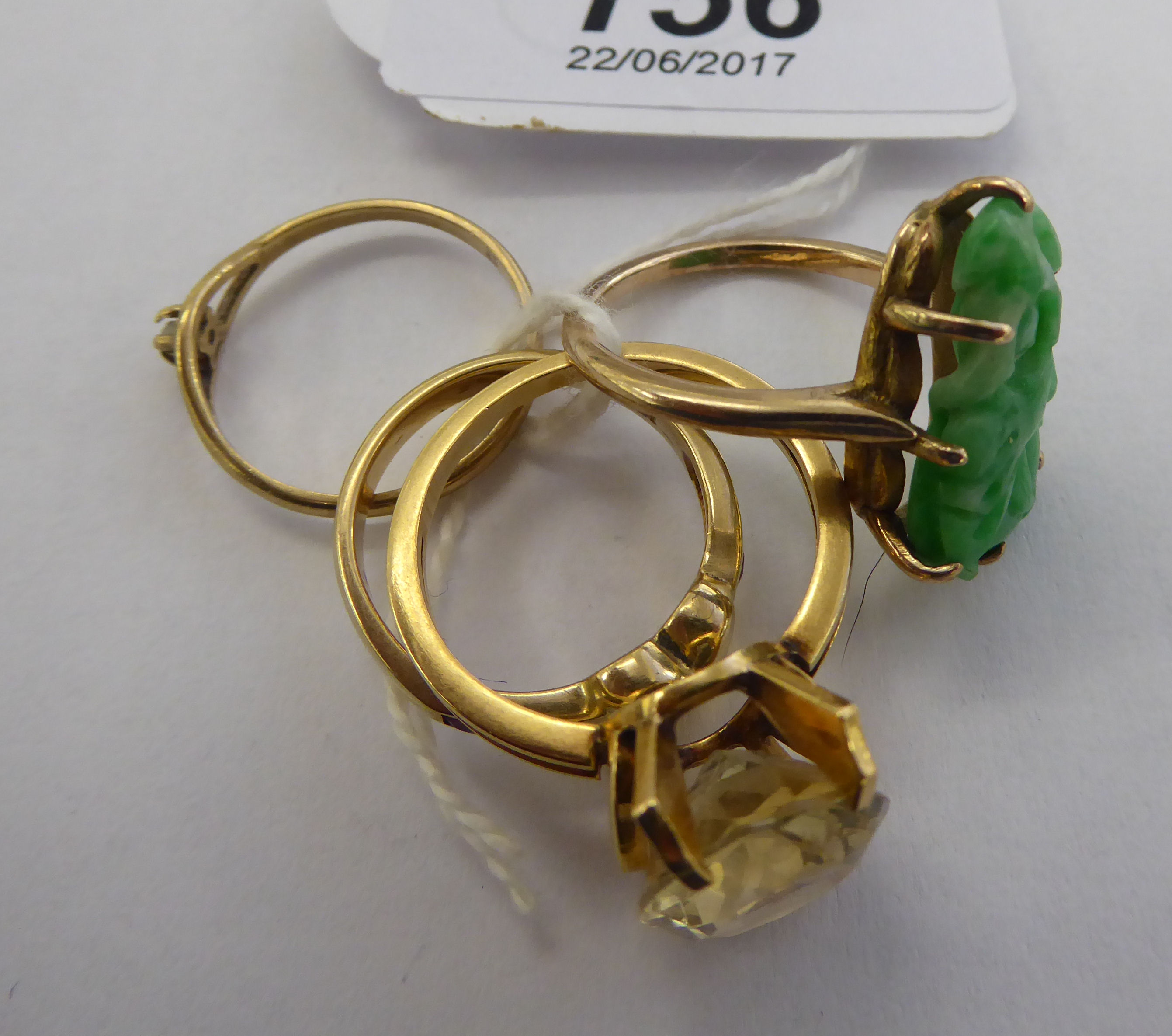 Four yellow metal rings: to include an example set with a jade tablet 11