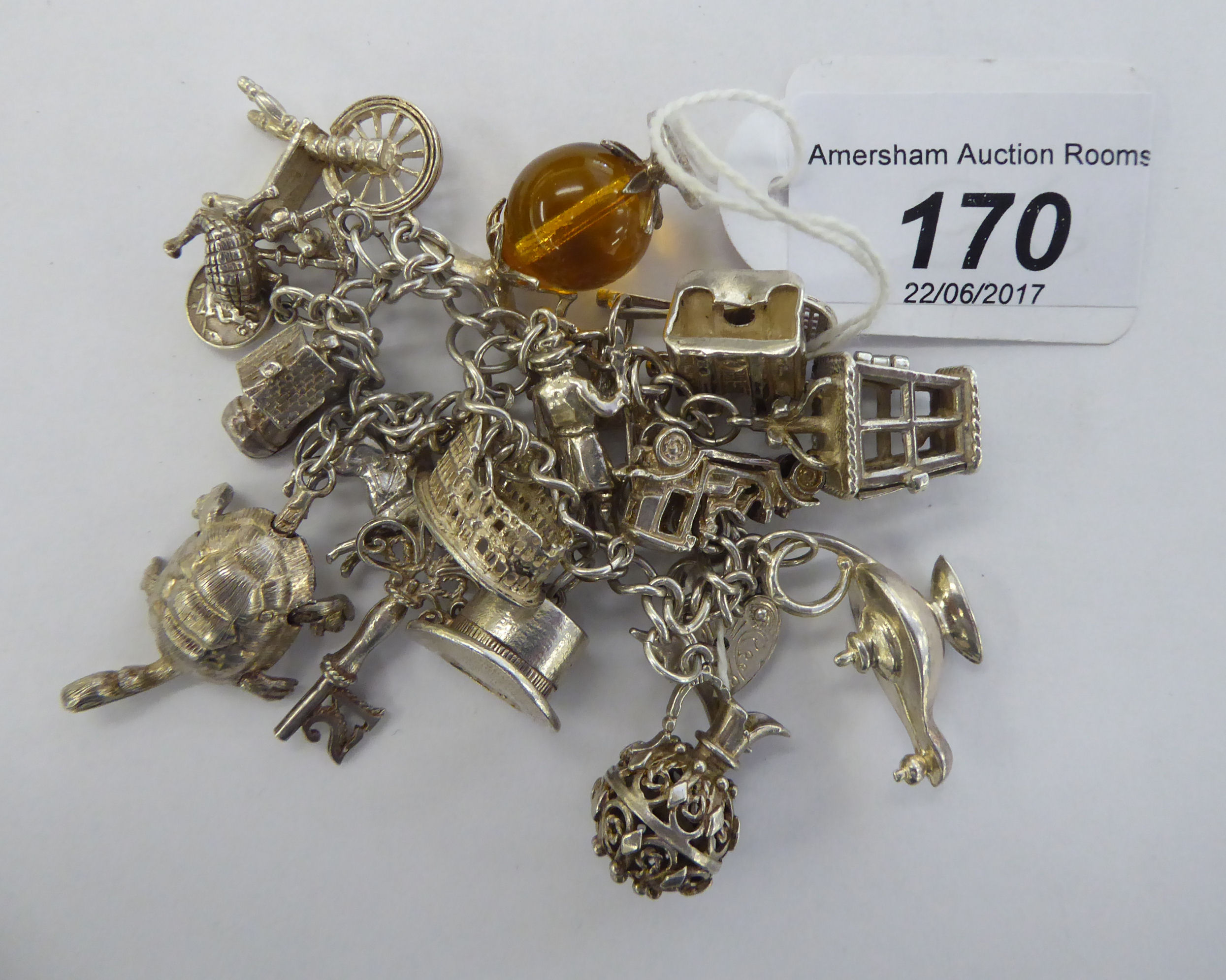 A silver and white metal charm bracelet: to include a turtle,