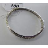 An 18ct white gold bangle of free-flowing form,