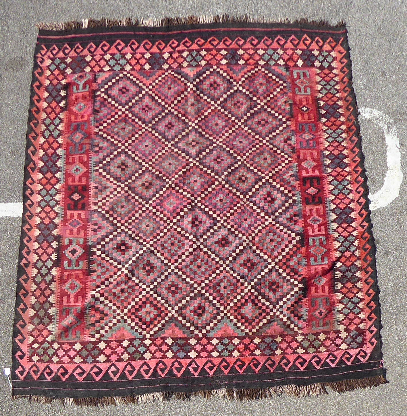 A Kelim rug with repeated diamond shaped motifs,