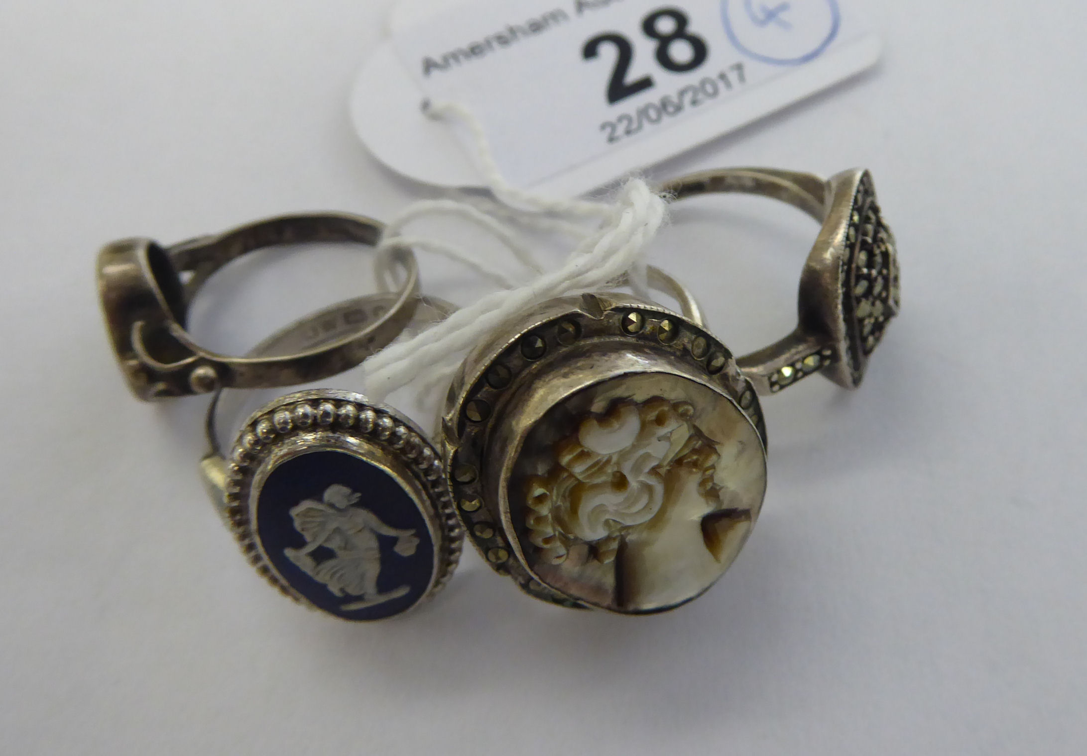 Four similar white metal rings: to include one set with an oval Wedgwood jasper stoneware tablet