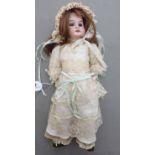 An Armand Marseille bisque head doll with painted features and weighted sleeping eyes,