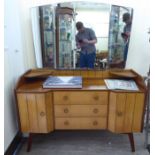 A mid 20thC mahogany finished dressing table, surmounted by a triptych mirror,