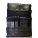 An early 20thC chinoiserie design black and gilt painted three tier waterfall front bookcase with