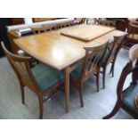 A 1960s G-Plan teak extending dining table, the top having curved ends,