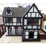 A Tudor style 'Market House' doll's house with lift-off panels and a hinged roof 31''h CA