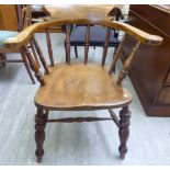 A late 19thC walnut and elm framed captain's chair with a horseshoe shaped spindle back, the solid,