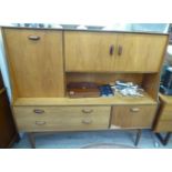 A 1960s G-Plan teak sideboard with an arrangement of cupboards, drawers and open shelves,