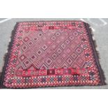 A Kelim rug with repeated diamond shaped motifs,