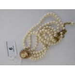 A triple row pearl necklace with a cameo,