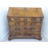 A George III walnut bureau with a fall front, enclosing a fitted interior,