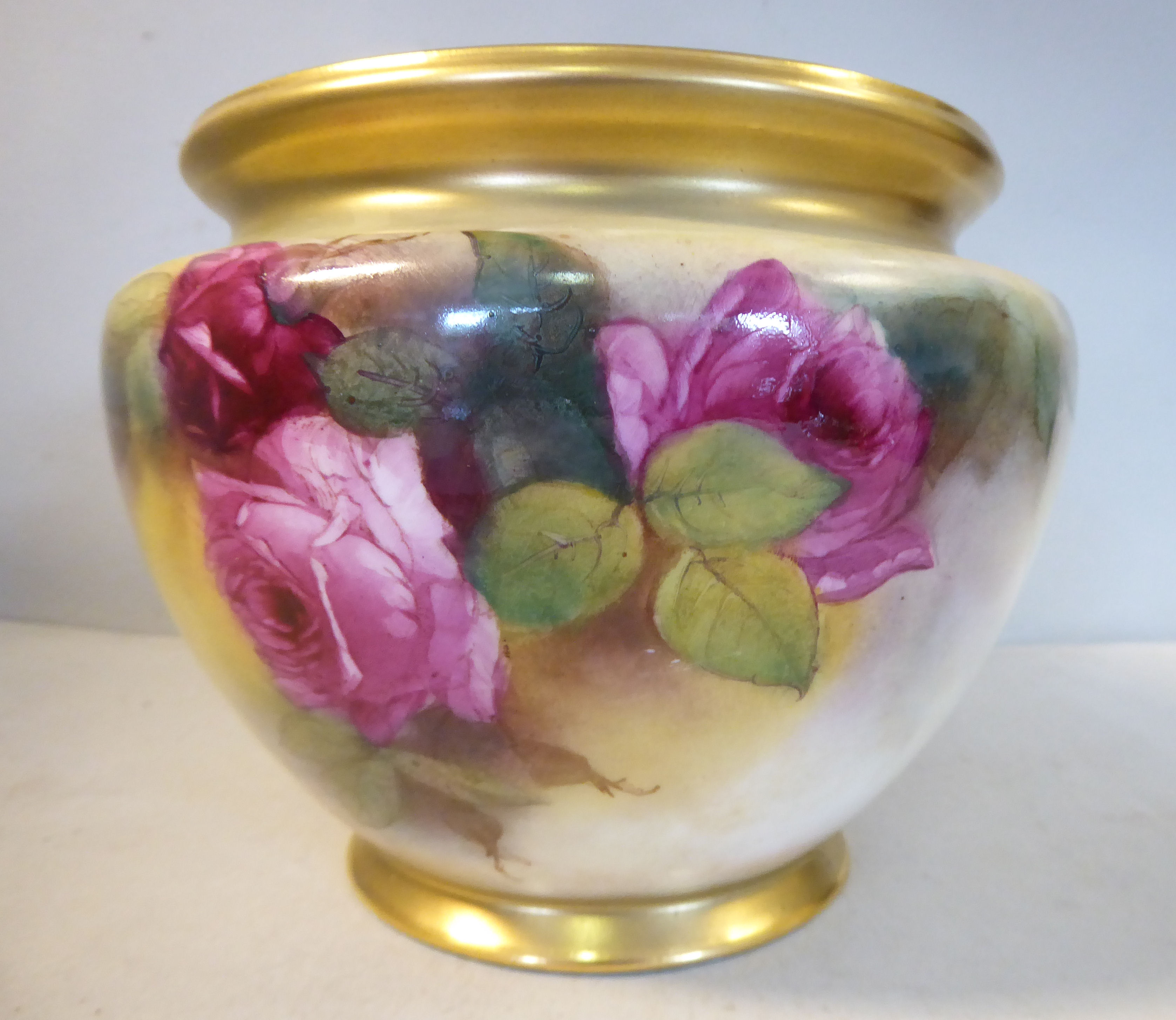 A Royal Worcester blush ivory glazed and mist gilded china jardiniere of squat, bulbous form,