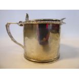 A Georgian style silver drum design mustard pot with a gadrooned rim, an angular loop handle,