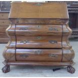 An early/mid 20thC Dutch figured walnut veneered bombe front bureau with decoratively scroll cast