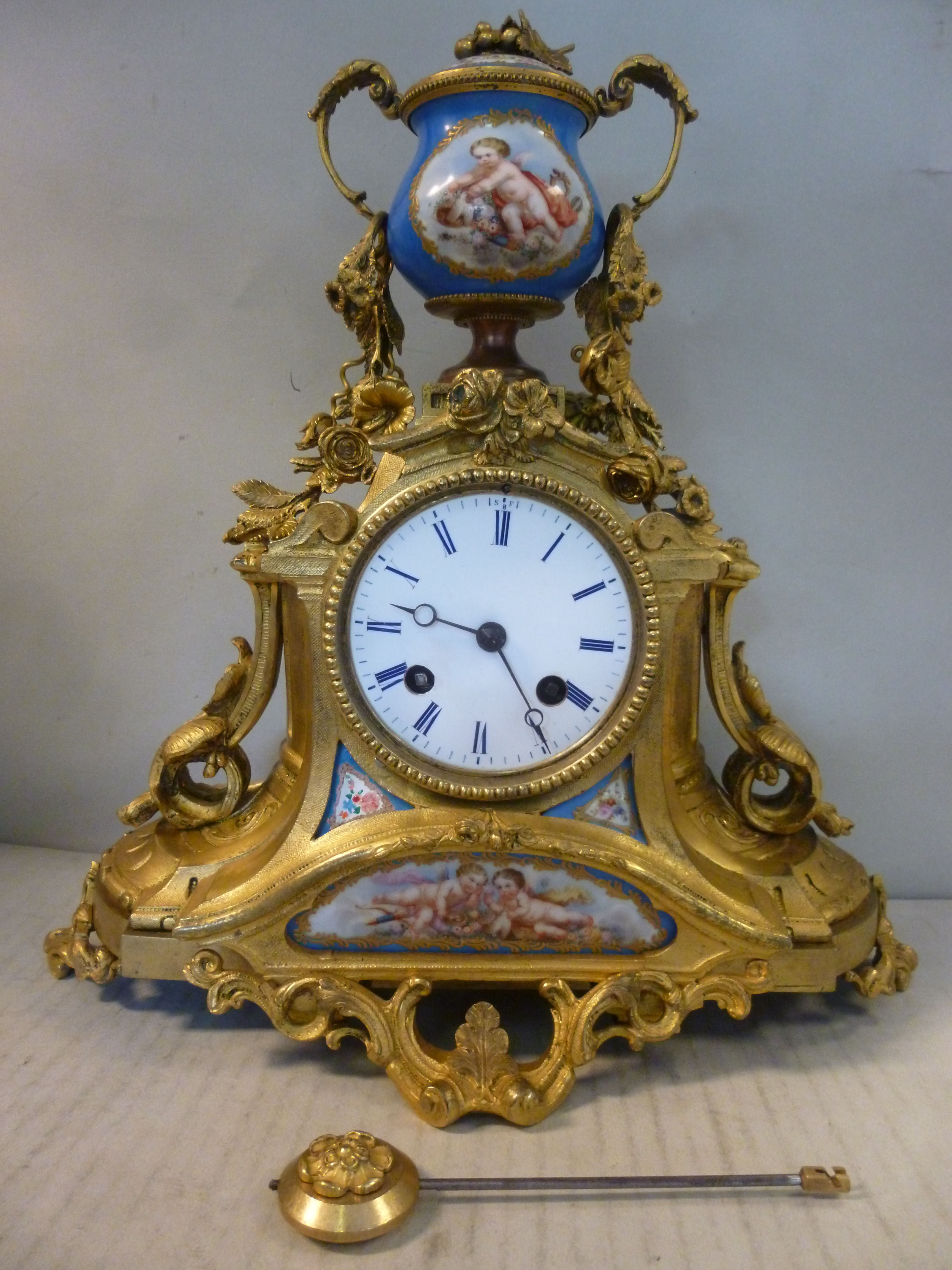 A late 19thC French floral and foliate cast gilt metal cased and painted porcelain mounted mantel