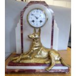 A French Art Deco mottled iron red and cream coloured marble and onyx cased mantel clock,