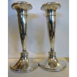 A pair of loaded silver candlesticks of tapered elliptical form with integral sockets and splayed