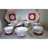 A Royal Crown Derby china tea set, decorated with dense flora, songbirds and gilded magenta bands,