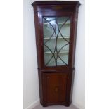 A George III satinwood inlaid mahogany corner cabinet with a marquetry frieze,