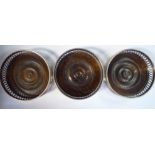 A set of three Georgian style turned mahogany and silver wine coasters with straight,
